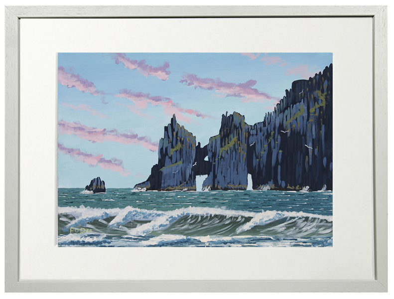 Framed artwork of coastal scene with cliffs and ocean waves.